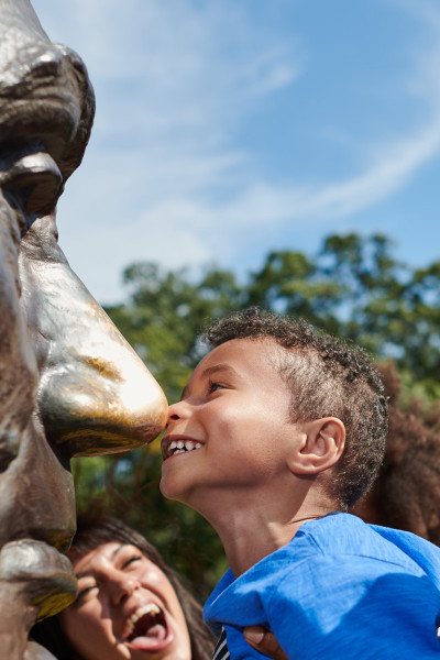 A young boy rubs his nose on Lincoln's bronze bust at Lincoln Tomb