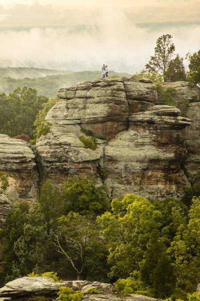 Hikers stand on a rocky outcrop in the Garden of the Gods, Southern Illinois.