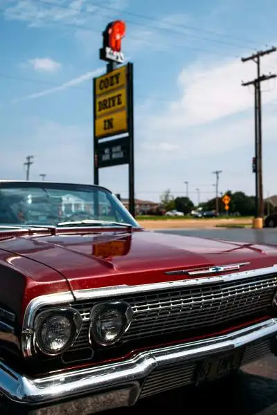 Car parked near Cozy Drive In sign