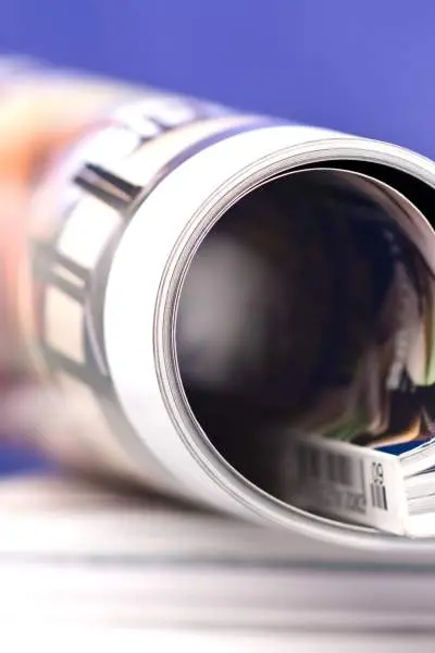 Photo of a rolled magazine sitting on a stack of magazines